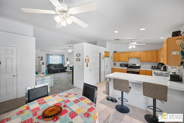 dining space featuring sink, light tile patterned floors, and lofted ceiling