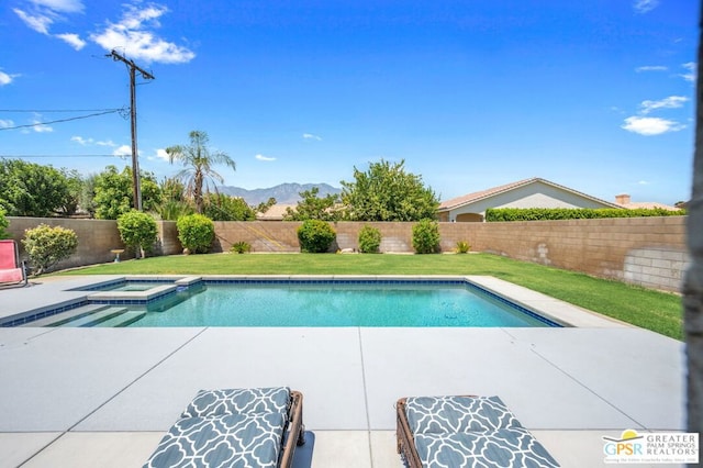 view of pool with a lawn, a mountain view, and an in ground hot tub