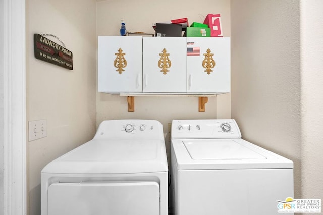 laundry room featuring washer and clothes dryer and cabinets