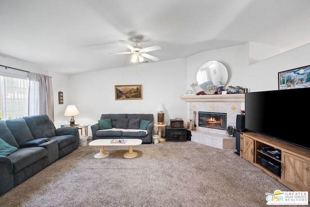 living room featuring carpet floors, ceiling fan, and a tile fireplace