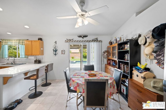 dining space featuring ceiling fan, light tile patterned floors, and sink