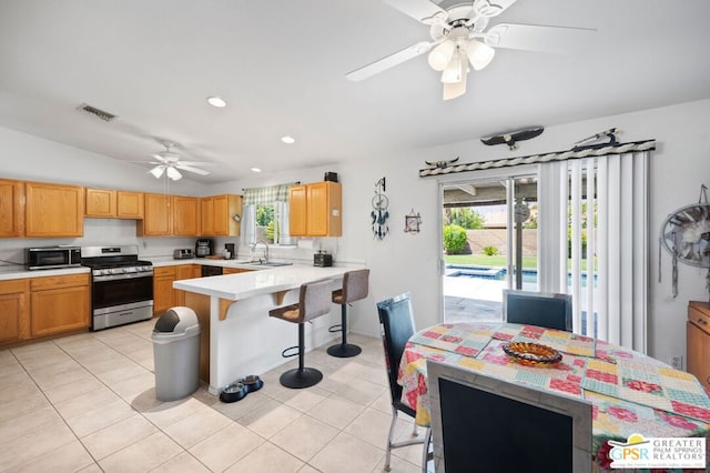 kitchen with ceiling fan, a wealth of natural light, appliances with stainless steel finishes, and light tile patterned flooring