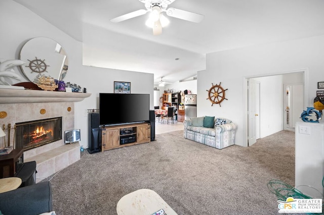 living room with ceiling fan, light colored carpet, lofted ceiling, and a fireplace