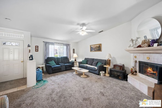 carpeted living room featuring ceiling fan and a tiled fireplace