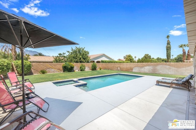 view of pool featuring an in ground hot tub, a yard, and a patio