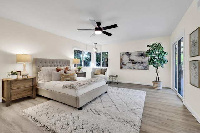 bedroom with ceiling fan, light hardwood / wood-style flooring, access to outside, and multiple windows