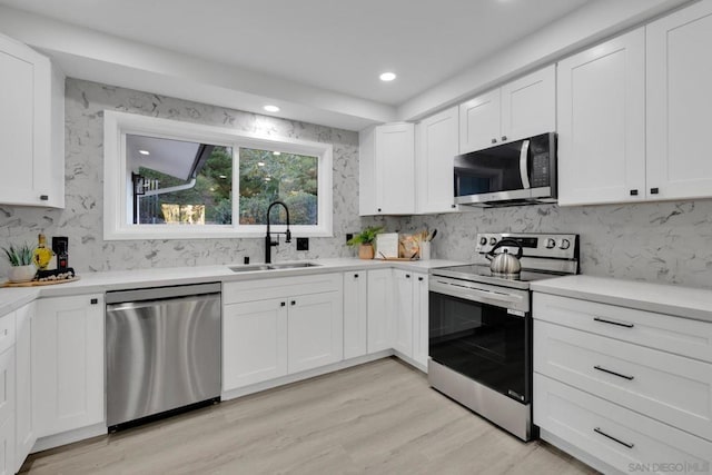 kitchen featuring light hardwood / wood-style floors, sink, white cabinets, and stainless steel appliances