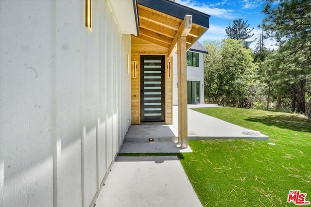 view of exterior entry with a yard