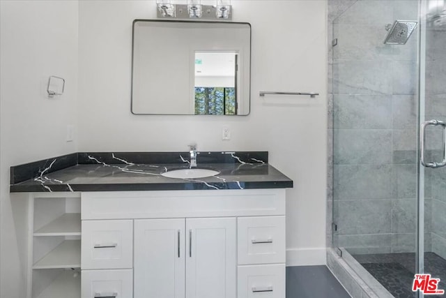 bathroom with a shower with shower door and vanity