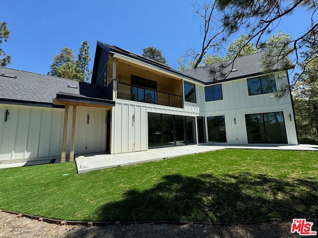 back of house with a lawn, a balcony, and a patio