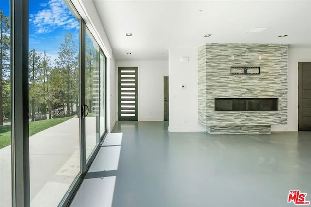 unfurnished living room with concrete floors and a fireplace