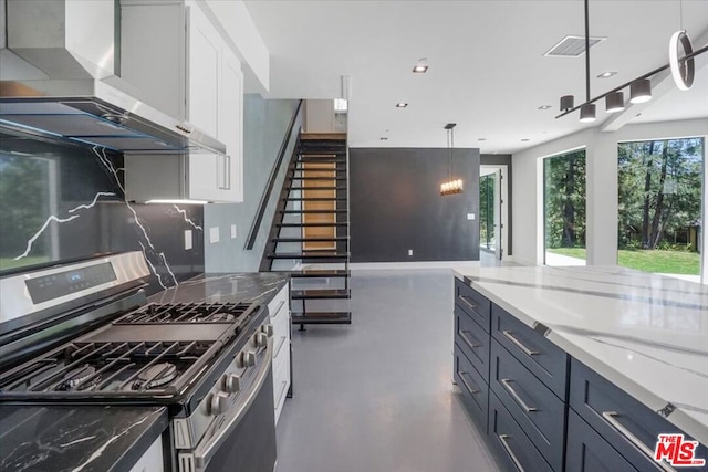 kitchen featuring wall chimney exhaust hood, white cabinetry, dark stone countertops, backsplash, and stainless steel range with gas stovetop