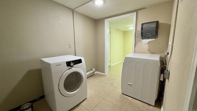 laundry area with light tile patterned floors and washing machine and dryer