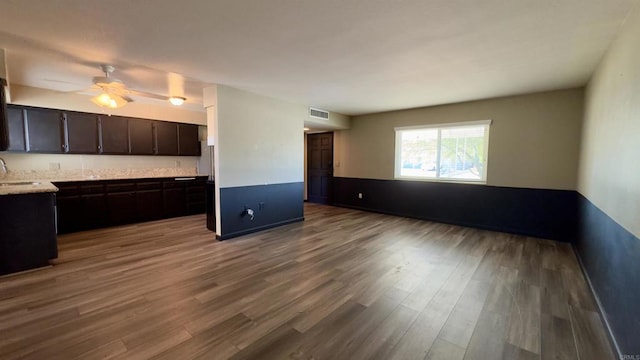 kitchen with ceiling fan, wood-type flooring, dark brown cabinetry, and sink