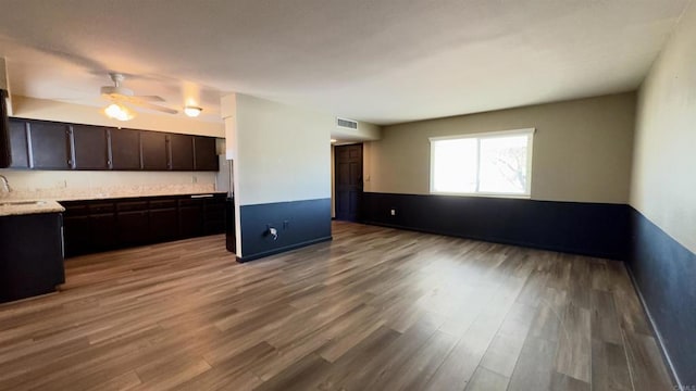 kitchen with ceiling fan, sink, dark brown cabinetry, and light hardwood / wood-style flooring