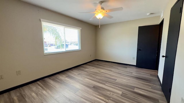 empty room with ceiling fan and light hardwood / wood-style floors