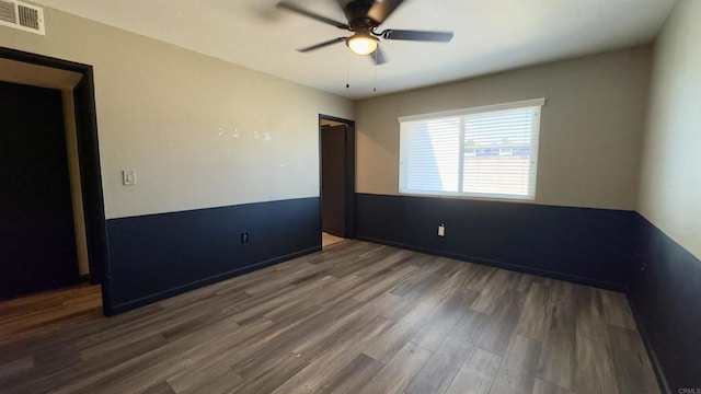 unfurnished bedroom featuring ceiling fan and dark hardwood / wood-style flooring