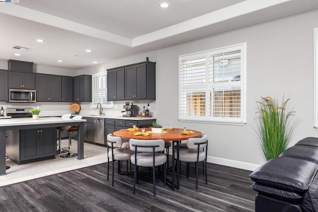 kitchen featuring sink, hardwood / wood-style floors, stainless steel appliances, and a breakfast bar area