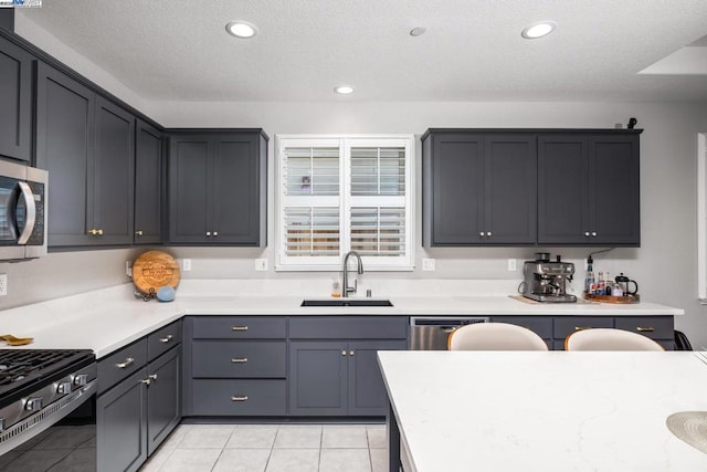 kitchen featuring light tile patterned floors, sink, and stainless steel appliances