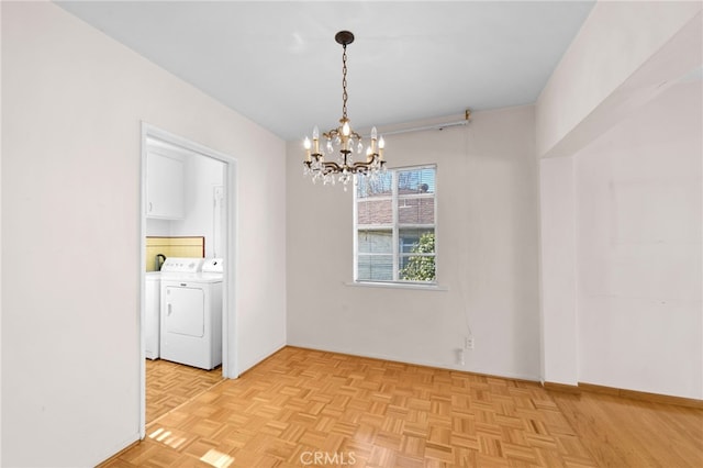 unfurnished dining area with light parquet flooring, a notable chandelier, and independent washer and dryer