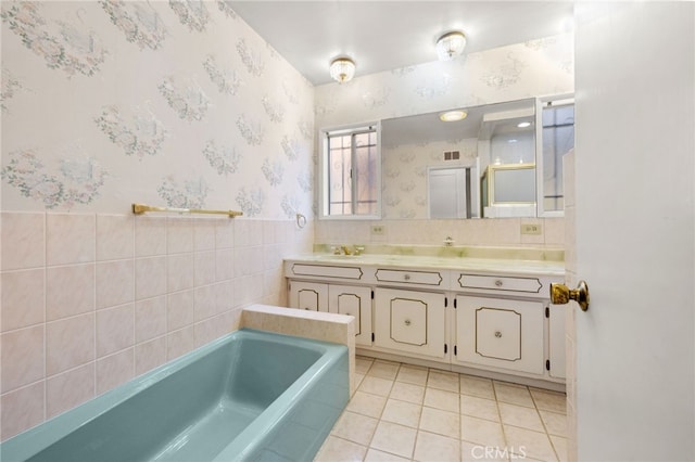 bathroom featuring tile patterned flooring, vanity, tile walls, and a bathing tub