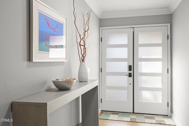 entryway with ornamental molding and french doors