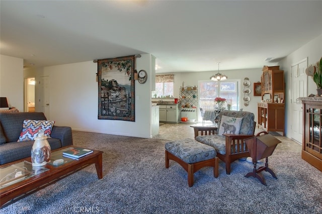 carpeted living room featuring an inviting chandelier