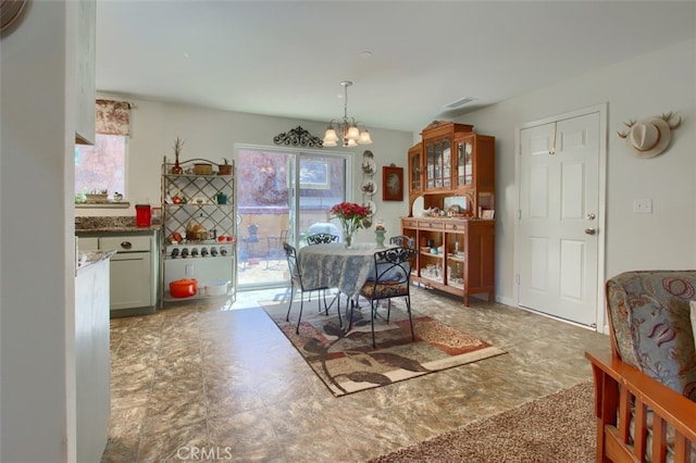 dining area with a wealth of natural light, carpet flooring, and an inviting chandelier