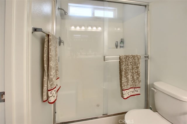 bathroom featuring toilet and an enclosed shower