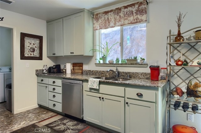 kitchen featuring washer / dryer, stainless steel dishwasher, and sink