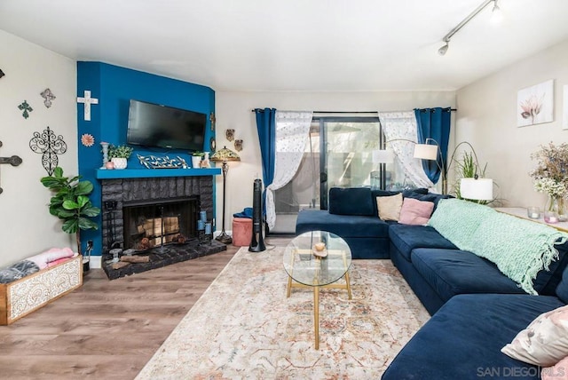 living room featuring hardwood / wood-style floors, a fireplace, and rail lighting