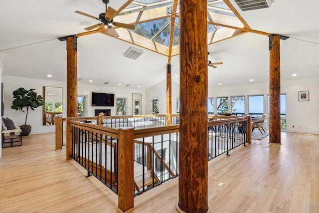 interior space featuring ceiling fan, wood-type flooring, and vaulted ceiling