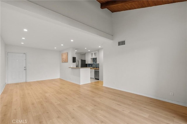 unfurnished living room featuring wooden ceiling, vaulted ceiling with beams, and light hardwood / wood-style floors