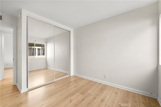 unfurnished bedroom featuring a closet and light hardwood / wood-style floors