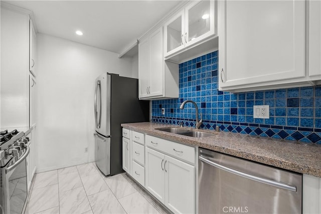 kitchen featuring white cabinets, appliances with stainless steel finishes, decorative backsplash, sink, and stone countertops