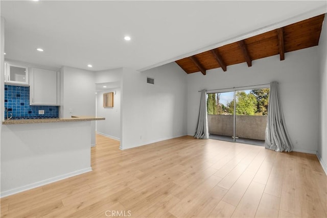 unfurnished living room featuring vaulted ceiling with beams, light wood-type flooring, and wooden ceiling