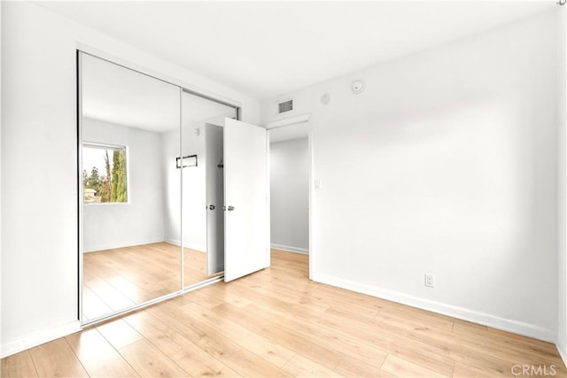 unfurnished bedroom featuring a closet and light hardwood / wood-style flooring