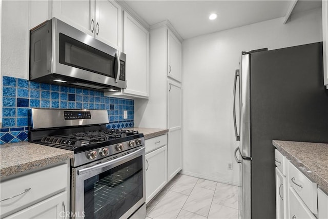 kitchen with appliances with stainless steel finishes, decorative backsplash, and white cabinets