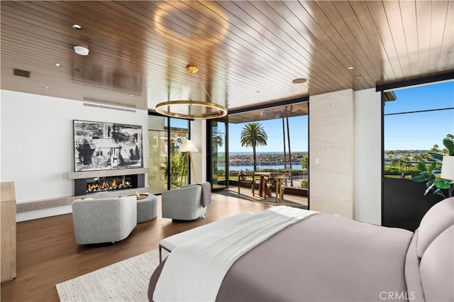 bedroom with floor to ceiling windows, a water view, hardwood / wood-style flooring, and wooden ceiling