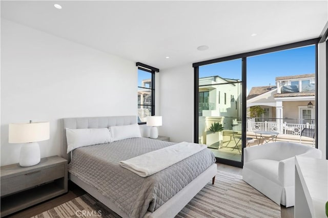 bedroom featuring a wall of windows and access to outside