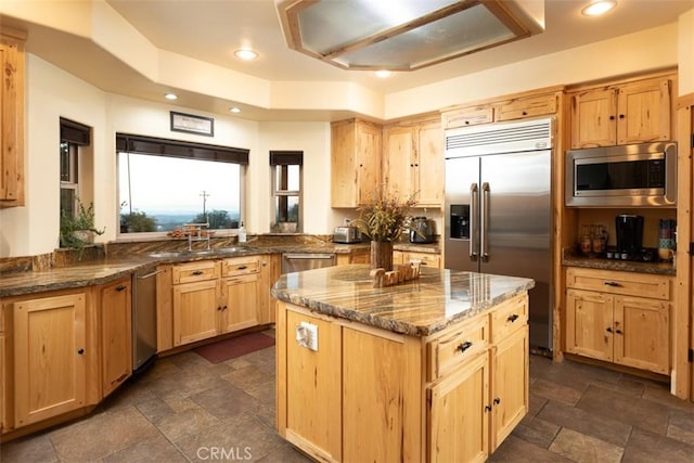 kitchen featuring built in appliances, stone finish floor, and recessed lighting