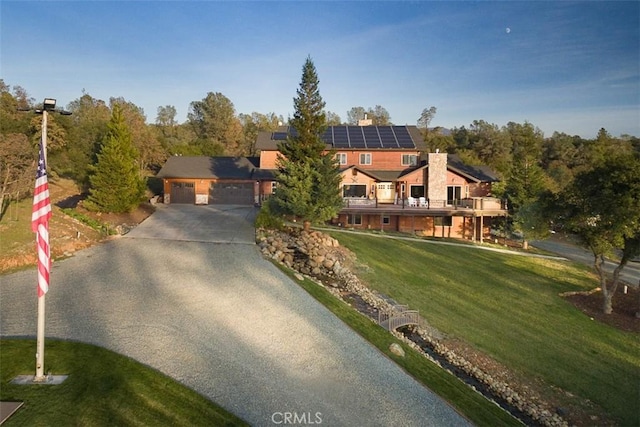 exterior space with a garage, solar panels, and a front yard