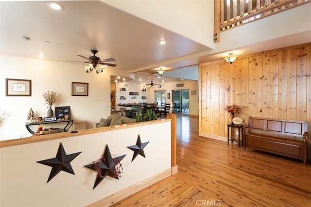 interior space featuring ceiling fan, recessed lighting, wooden walls, wood finished floors, and baseboards