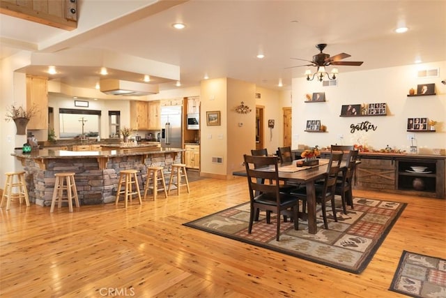 dining area featuring light wood-type flooring, bar, visible vents, and recessed lighting