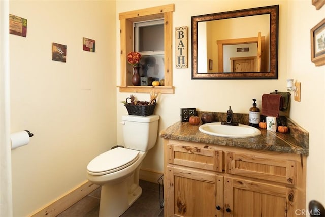 bathroom featuring toilet, tile patterned floors, baseboards, and vanity