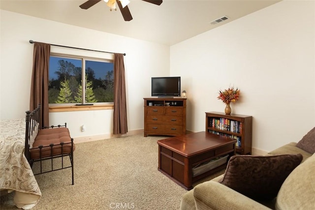 living area featuring carpet floors, ceiling fan, visible vents, and baseboards