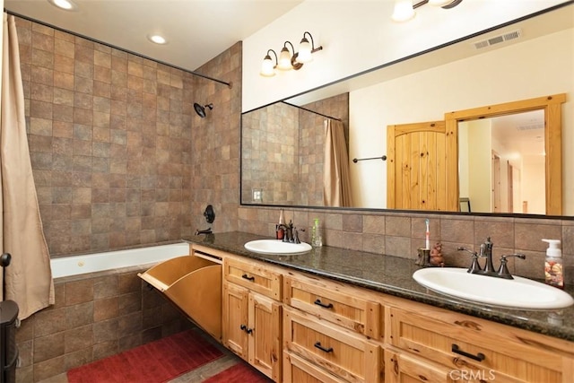 full bath with double vanity, tiled shower / bath combo, a sink, and decorative backsplash