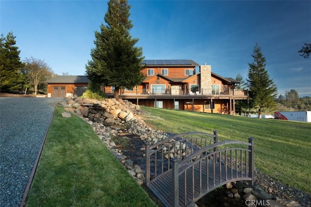 view of front facade featuring a front lawn and solar panels