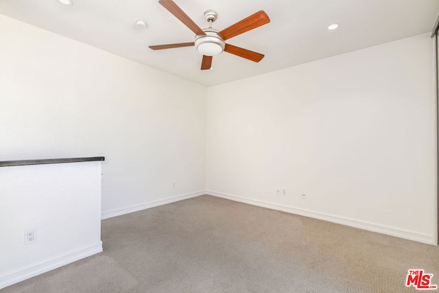 carpeted spare room with ceiling fan