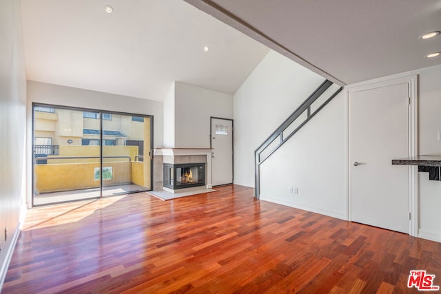 unfurnished living room with a multi sided fireplace and hardwood / wood-style floors